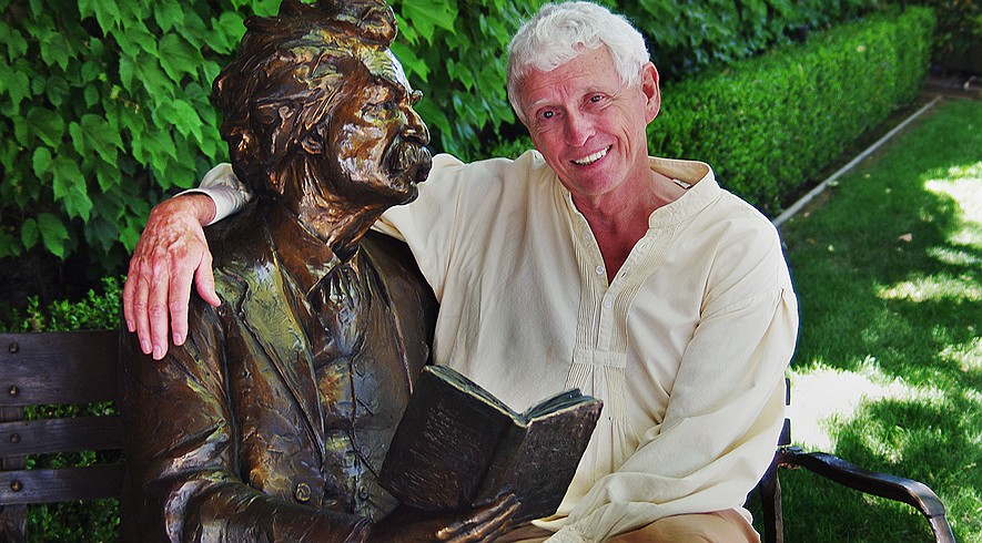 Jim Fletcher, the "official storyteller of Calaveras County," with a bronze statue of Mark Twain on May 6, 2015, at Camps Restaurant in Angels Camp, California, where he gives a weekly presentation on Twain's mining days in California.