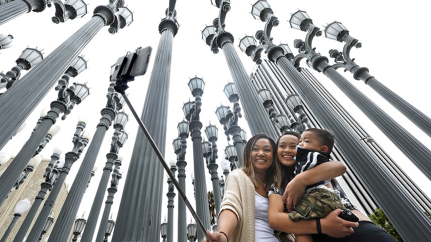 Marjorie Mabini (left) takes a selfie with her niece, Jaydah Mabini, and son, Jaren, 1, in front of the "Urban Light" lamppost installation at the Los Angeles County Museum of Art on May 27, 2015, in Los Angeles, California. They were visiting from Oahu, Hawaii.