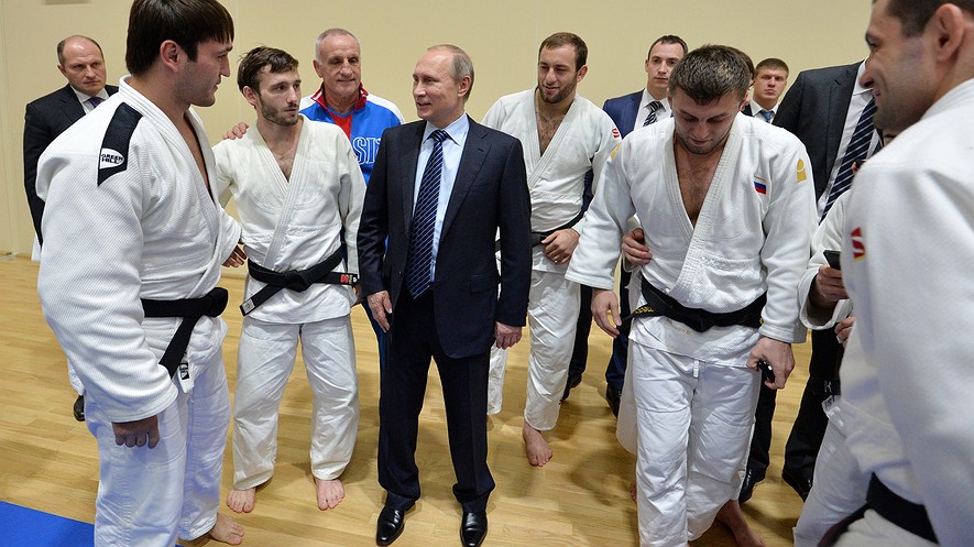 Russian President Vladimir Putin (center) speaks to athletes during a visit to the federal government center "South Sports" before his late-night meeting with the heads of Russia's sports federations in the Black Sea resort of Sochi, Russia, Nov. 11, 2015.