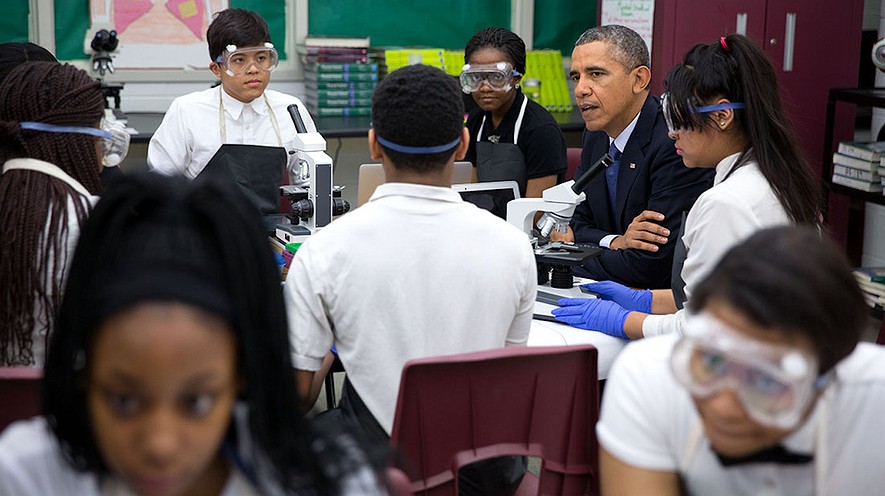 El Presidente Barack Obama se reúne con estudiantes en su aula de ciencias biomédicas en la Escuela Secundaria Bladensburg en Bladensburg, Maryland, el 7 de abril de 2014. Cuando Barack Obama fue presidente hizo una nueva ley. La ley se llama _Every Student Succeeds Act_. En español se llama la Ley Cada Estudiante Triunfa. Ahora, los legisladores estatales están preparando sus planes para cumplir con la ley. Foto: Pete Souza / White House