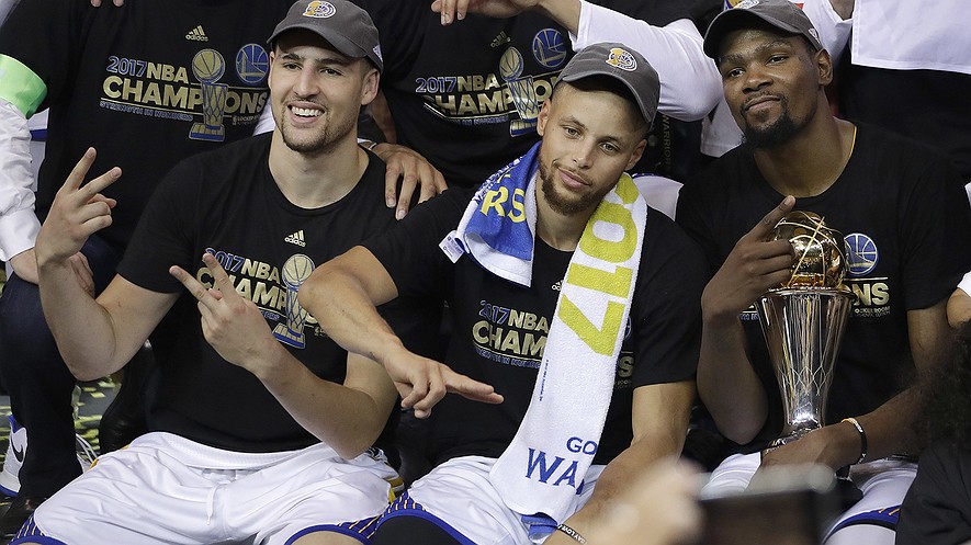 El base del Golden Sate Warriors Klay Thomson, desde la izquierda, el base Stephen Curry y el pívot Kevin Durant celebran tras el quinto partido de las finales de la NBA contra los Cleveland Cavaliers en Oakland, California, el lunes 12 de junio del 2017. Los Warriors ganaron 129-120 para hacerse con el campeonato de la NBA. Fotografía por: AP Photo / Marcio José Sánchez