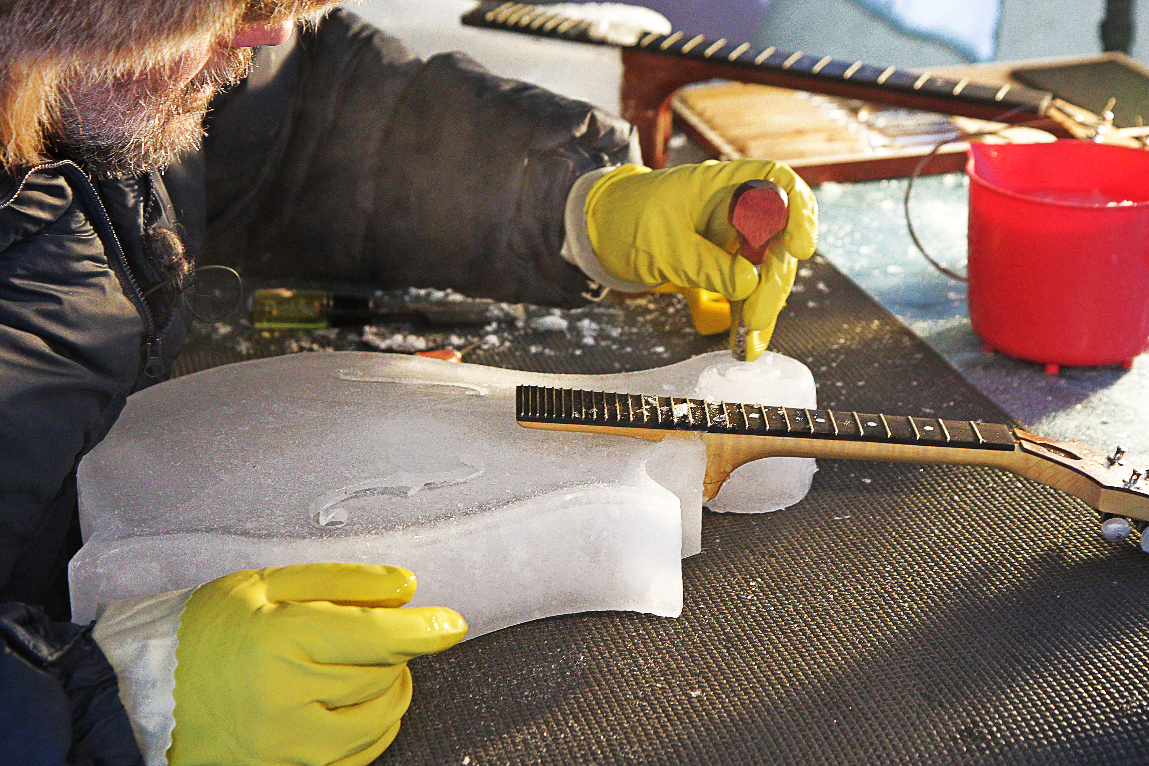 photo of a man carving a violin out of ice.